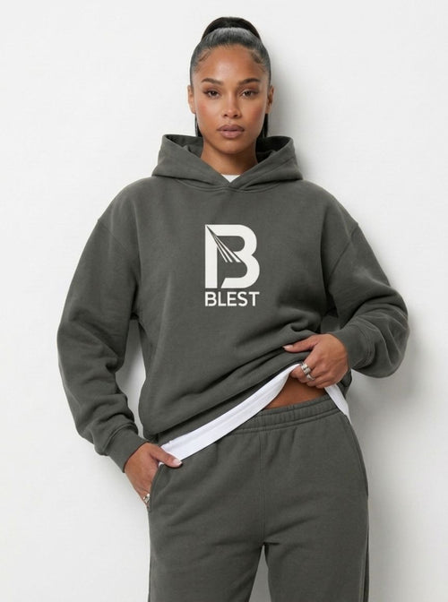 woman posing with the Blest grey pullover hoodie with white B Blest logo